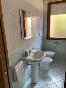 a bathroom with a sink and a toilet at Regina House Cattolica in Cattolica