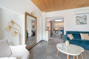 a living room with a blue couch and a mirror at Lora luxury villa , with lake view, air conditioner every room in Ossuccio