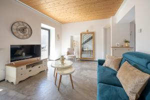 a living room with a blue couch and a tv at Lora villa, with lake view in Ossuccio