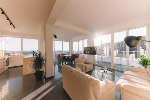a living room with white furniture and large windows at La Mer Beach Residence in Ulcinj