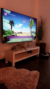 a large flat screen tv in a living room at Maison neuve cocooning 6 personnes Avec Spa et piscine chauffée in Moyenmoutier