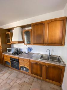a kitchen with wooden cabinets and a sink and a stove at Regina House Cattolica in Cattolica +14 photos