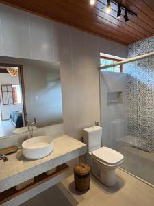 a bathroom with a toilet and a sink and a shower at Vilarejo Ibitipoca in Conceição da Ibitipoca