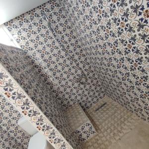 a bathroom with a floral patterned wall at Chambre Suite Paco avec accès piscine in Midoun +9 photos