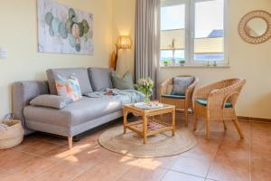 a living room with a couch and chairs and a table at Auszeit zu zweit - Usedom Ferienwohnungen Tannengrund in Loddin