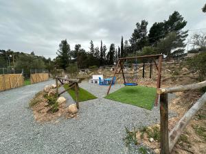 a playground with a swing set on a gravel road at Villa Blue Paradise Relax con piscina a pochi minuti da Cagliari e dal mare in Cagliari
