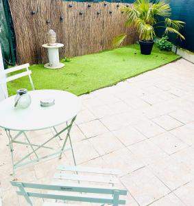 a patio with a white table and a chair at Jungle Love Loveroom avec Balnéo à 10 min de Disneyland Paris in Serris