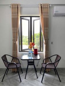 a table and two chairs in a room with a window at Tamcoc Sunseekers Homestay & Hostel in Ninh Binh