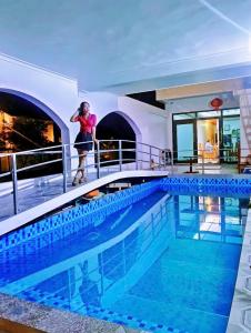 a woman standing next to a swimming pool on a cruise ship at Tamcoc Sunseekers Homestay & Hostel in Ninh Binh
