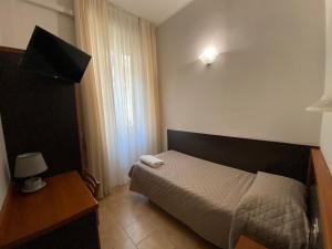 a small bedroom with a bed and a television at Hotel Atena in Milan