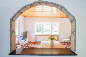 an archway in a living room with a table and a television at Ferienhaus am See -Teichanlage Kern in Oberelbert