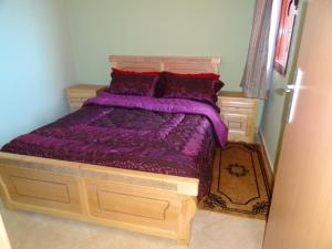 マラケシュにあるApartment Twins 12のベッドルーム(紫色の掛け布団付きのベッド1台付)