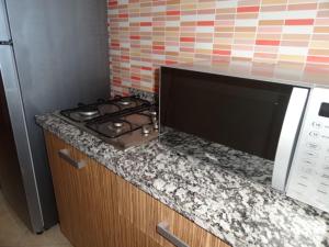 马拉喀什Apartment Twins 12的带炉灶和微波炉的厨房柜台 更多23张照片