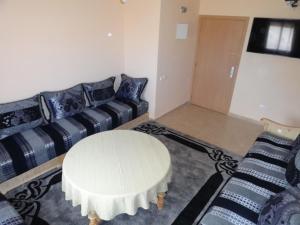 马拉喀什Apartment Twins 12的客厅里有一张白色的桌子和一张沙发