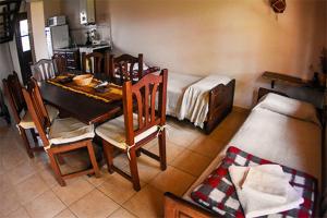 a room with a table and chairs and a kitchen at Costa Marina cabañas in Miramar