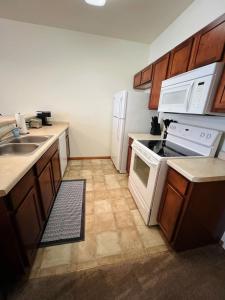 a kitchen with white appliances and wooden cabinets at Studio 104 at Foxboro in Oregon