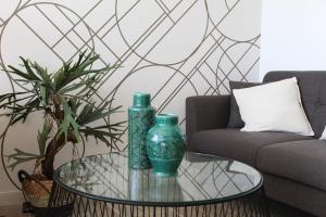 アントファガスタにあるHOM I Vista al Mar Depto Studio Piscina 0816 PNMのリビングルームのガラスのテーブルの上に置かれた2つの緑の花瓶