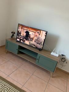 a flat screen tv sitting on top of a table at Casa Aconchegante em Aparecida - 600 metros da Basílica in Aparecida