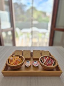 a wooden tray with three baskets of sandwiches and snacks at Appartamento a 100m dal mare in Grottammare