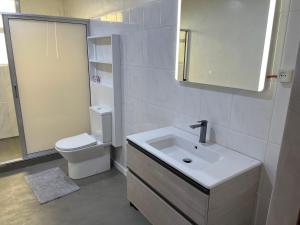 a white bathroom with a sink and a toilet at Villa do Monte Sunset in Porto Moniz +21 photos