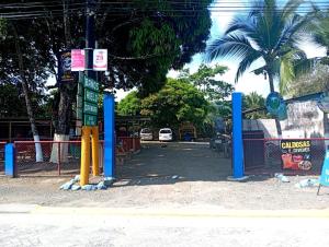 希门尼斯港Allalu Camping Corcovado的拥有蓝色吊杆和街道的停车场