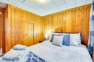 a bedroom with wooden walls and a bed with blue pillows at Mountain Retreat at Base of Pikes Peak! in Cascade-Chipita Park
