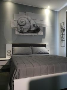 カターニアにあるLuca's Garden B&B in Cataniaの大きなベッド付きのベッドルーム1室、壁に絵画が飾られています。