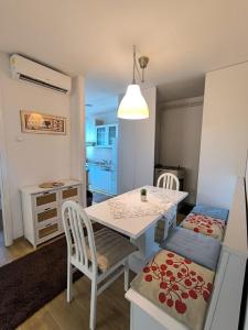 een keuken en eetkamer met een tafel en stoelen bij Esma 2 in Bihać