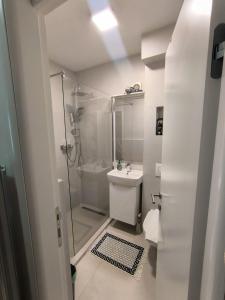 een badkamer met een douche, een toilet en een wastafel bij Esma 2 in Bihać