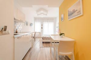 a kitchen with a white table and a yellow wall at MiniSuites iCostaioli in Maiori