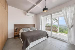a bedroom with a bed and a large window at Amazing Oceanview Villa with Private Pool - Fast WiFi in Ojochal