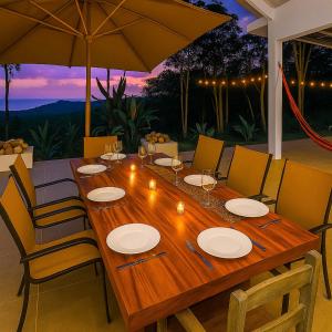 a wooden table with chairs and an umbrella on a patio at Amazing Oceanview Villa with Private Pool - Fast WiFi in Ojochal