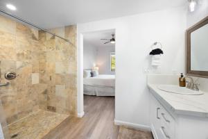 un bagno bianco con doccia e lavandino di Oceanfront 2BR Rooftop Deck Beach Access Strand Way B a Oceano