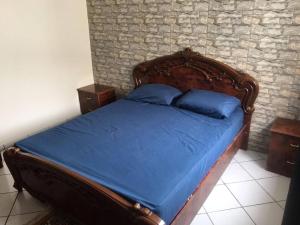 a bedroom with a wooden bed with blue pillows at Appartement situé en plein cœur d'Agadir in Agadir