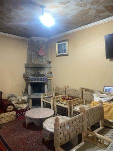 a living room with a room with a fireplace at Maison d'hôtes Moussem des fiançailles in Imilchil