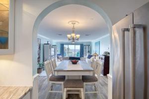 Un comedor y una cocina con mesa y sillas. en Oceanfront Elysium with a pool, en Ormond Beach
