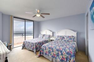 a bedroom with two beds and a ceiling fan at Paradise on the beach with pool in Daytona Beach +45 photos