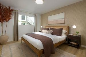 a bedroom with a large bed and a window at Private Garden and Tranquil Haven in Summerland