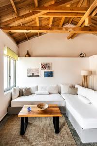 a living room with a white couch and a wooden table at Rock Solid Stone House - Chora Samothraki in Samothraki