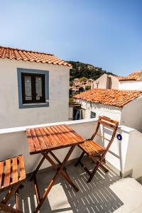 a wooden table and chairs on a balcony at Rock Solid Stone House - Chora Samothraki in Samothraki