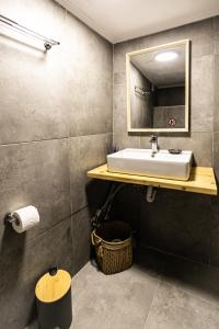 a bathroom with a sink and a mirror at Rock Solid Stone House - Chora Samothraki in Samothraki +33 photos