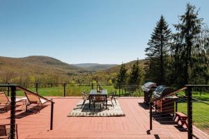 a patio with a table and chairs on a deck at Catskills Arthouse - 15 mins to Skiing in Margaretville