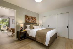 a bedroom with a large bed and a table at Private Balcony and Coastal Escape in Summerland