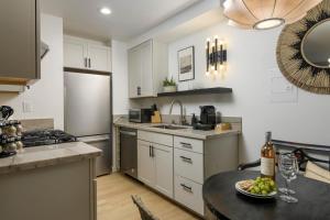 a kitchen with a table with a plate of fruit on it at Private Balcony and Coastal Escape in Summerland