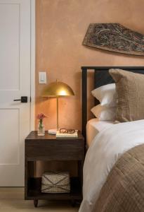 a bedroom with a bed and a table with a lamp at Bali Home and SB Beaches in Summerland