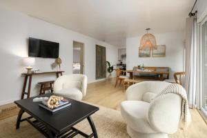 a living room with white chairs and a table at Group-Friendly and Tranquil Oasis in Summerland