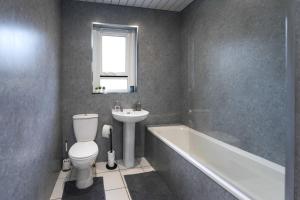 a bathroom with a toilet and a sink and a bath tub at Barassie Villa located near Troon in Troon +6 photos