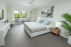 克瓦拉海滩Kewarra Beach Studio Apt with Resort Pool and BBQ的一间卧室，里面有一张床、一张沙发和一张桌子