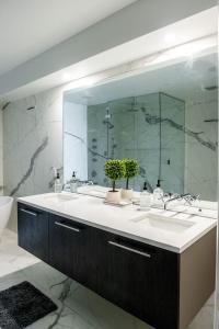 a bathroom with a sink and a large mirror at Chic Luxury 4BR Townhome with NYC Views in North Bergen +29 photos