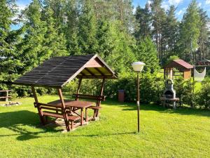 a picnic table with a gazebo in the grass at Domek wakacyjny in Sumowo